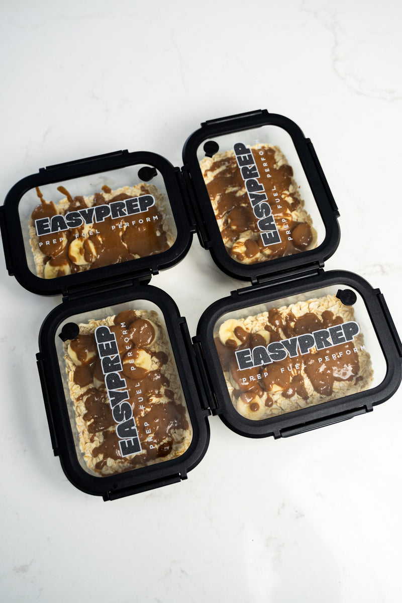 Four charcoal Easy Prep containers with prepared breakfasts